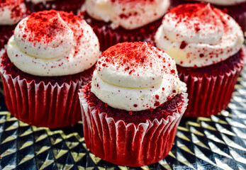 red velvet mini cupcakes each topped with a swirl of vanilla frosting sprinkled with red sugar