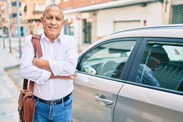 Senior man smiling happy standing over car at the city.