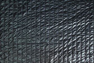 Dark fashionable quilted fabric in black. Abstract background