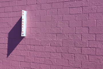 pink brick wall with sign