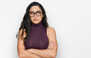 Brunette young woman wearing casual clothes and glasses skeptic and nervous, disapproving expression on face with crossed arms. negative person.