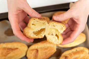 Chef shows the middle of workpiece for profiteroles, puffs, popovers, eclair.