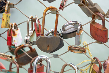 Fototapeta na wymiar Love padlocks with heart shape. Concept of love. Metallic love padlock on a bridge full of padlocks.