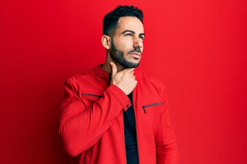 Young hispanic man wearing red leather jacket touching painful neck, sore throat for flu, clod and infection