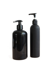 Black cosmetic bottles isolated on white. Plastic containers of various sizes for cosmetics.