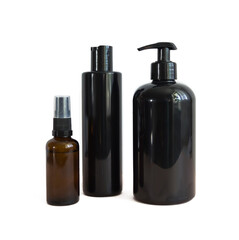 Black cosmetic bottles isolated on white. Plastic containers of various sizes for cosmetics.