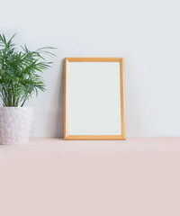 Framed blank sheet mockup, home decor. Simple composition of beetle decor, picture frame, plant.