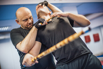 Instructor and student practice filipino escrima stick fighting technique