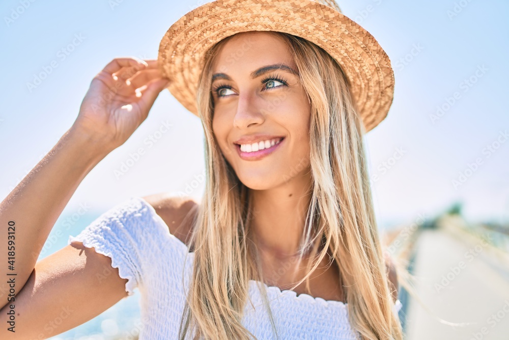 Wall mural young blonde tourist girl smiling happy looking to the side walking at the promenade.