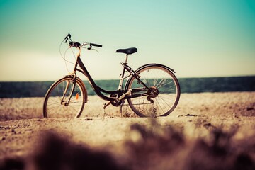 Fototapeta na wymiar bicicleta de paseo en la playa frente al mar, vieja estilo teal y orange