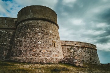 Fototapeta na wymiar Torre de defensa redonda en el castillo fortaleza costera de Guardias Viejas, Almería, España