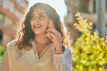 Young hispanic woman smiling happy talking on the smartphone at the city.