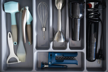 Open drawer with different utensils and cutlery in kitchen, above view.
