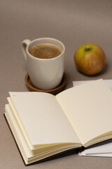 coffee and notebook and apple o gray background with lights 
