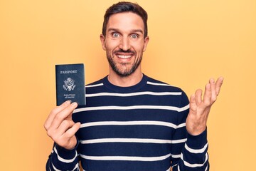 Young handsome tourist man holding united states passport over isolated yellow background...