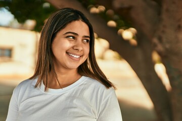 Young latin girl smiling happy standing at the park.