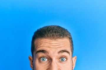 Young caucasian man showing head and half face celebrating crazy and amazed for success with open eyes screaming excited.