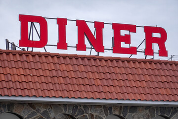 Red Diner sign on the tile roof of a building