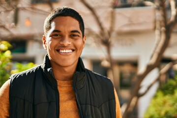 Young latin man smiling happy standing at the city