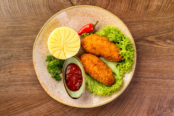 two chicken cutlets on a leaf of lettuce, mashed potatoes and tomato sauce. Kiev-style cutlets
