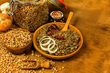 Lentils with sausage and chili. Grilled sausage and lentils with egg on a black plate. Legumes. Healthy food.