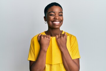 Young african american woman holding book winking looking at the camera with sexy expression,...