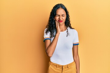 Obraz premium Young african american girl wearing casual clothes touching mouth with hand with painful expression because of toothache or dental illness on teeth. dentist