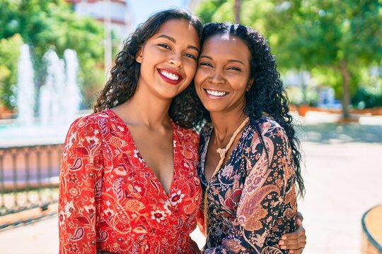 African american mother and daughter smiling happy hugging at the park.