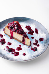 Colorful and fresh tasty cheesecake with berries in a blue plate