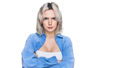 Young blonde girl wearing casual clothes skeptic and nervous, disapproving expression on face with crossed arms. negative person.