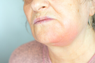 Depressed mature woman isolated on grey studio background touch cheek suffering from tooth pain