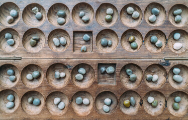 Antique Boa Mancala tradition African Board Game. Vintage Bao carved wooden Board Game. With natural baobab tree seeds Balls.