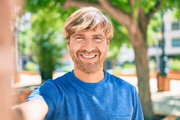 Fototapeta premium Young irish man smiling happy making selfie by the camera at the park.