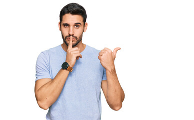 Young hispanic man wearing casual clothes asking to be quiet with finger on lips pointing with hand...