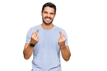 Young hispanic man wearing casual clothes showing middle finger doing fuck you bad expression,...