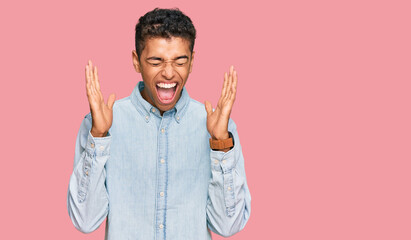 Young handsome african american man wearing casual clothes celebrating mad and crazy for success...