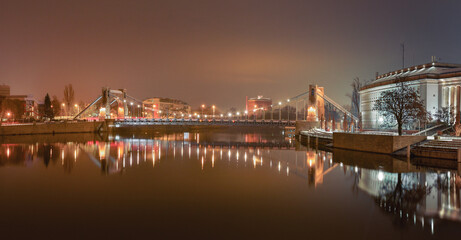 Fototapeta na wymiar Grunwaldzki Bridge in Wroclaw on the Odra River, illuminated at night.