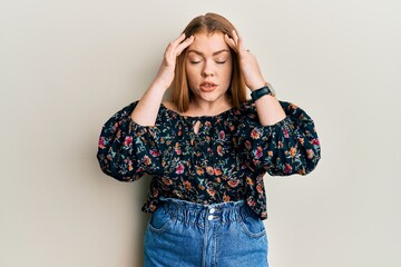 Young beautiful redhead woman wearing casual floral clothes with hand on head, headache because stress. suffering migraine.