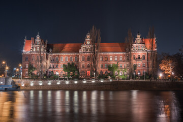 Fototapeta na wymiar Wroclaw National Museum on the Odra River, night view from the shore.