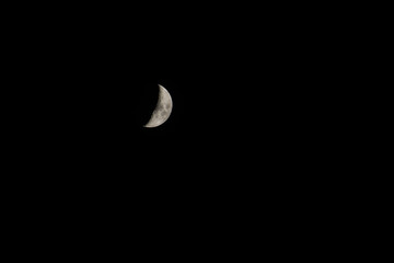Obraz na płótnie Canvas The first quarter of the moon in the sky.