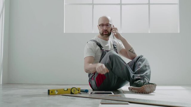 Taskmaster draws on tablet talking on mobile phone in room