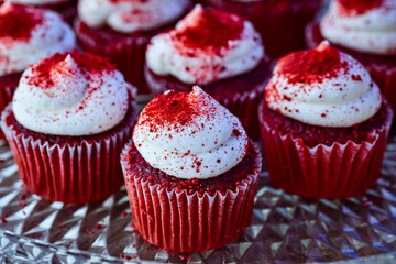red velvet mini cupcakes each topped with swirl of vanilla frosty sprinkled with red sugar