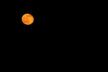 A cold full moon, a natural satellite against the dark sky.