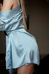 a young, beautiful woman in a blue nightgown. selective focus with a small focus area. crop without a face on the details