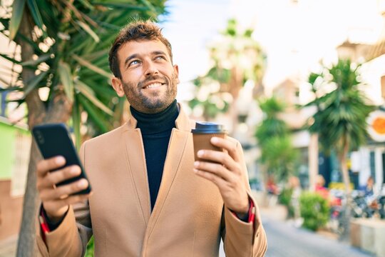 Handsome business man wearing elegant jacket using smartphone smiling happy outdoors