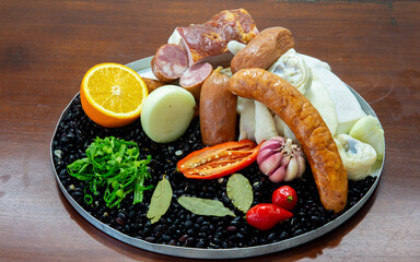 Typically Brazilian feijoada, ingredients, pepperoni sausage, paio, pepper, pork, black beans, bay leaf, cracklings and caipirinha with lemon and cachaça