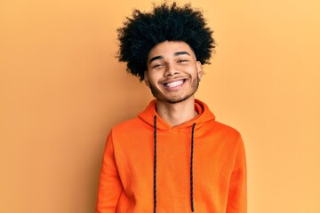 Fototapeta na wymiar Young african american man with afro hair wearing casual sweatshirt with a happy and cool smile on face. lucky person.