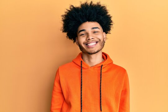 Young african american man with afro hair wearing casual sweatshirt with a happy and cool smile on face. lucky person.