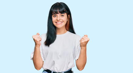 Young hispanic girl wearing casual clothes celebrating surprised and amazed for success with arms raised and open eyes. winner concept.