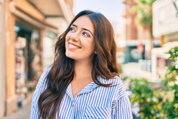 Young hispanic businesswoman smiling happy walking at the city